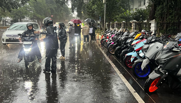 Suasana hujan deras di depan Gedung Sate, Kota Bandung, tidak menyurutkan niat para member Komunitas OXI untuk berbagi takjil pada Jumat (14/03/2025) - (Sumber: Eriez)