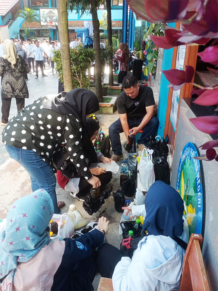 Captionan: Tim ASIX Go Green sedang mengumpulkan donasi mijel ke dalam jerigen di SMPN 6 Bandung